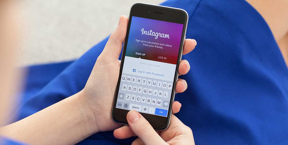 Person hält Smartphone mit Login Startseite von Instagram